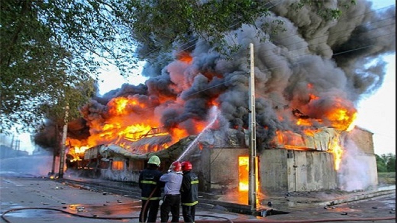 شعله‌های آتش در محاصره آتش نشانان