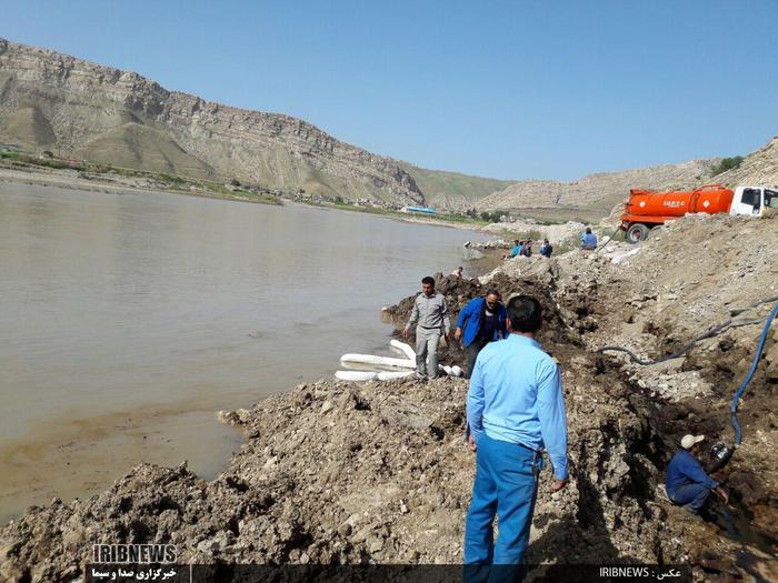 تلاش عوامل شرکت نفت و محیط زیست پلدختر برای خارج کردن مواد نفتی از رودخانه کشکان در پی شکست خط انتقال نفت خام در منطقه مورانی